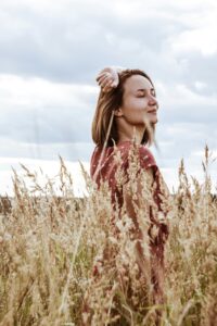 Femme épanouie grâce à la sophrologie qui améliore son bien-être au quotidien en diminuant son stress et favorisant son sommeil.